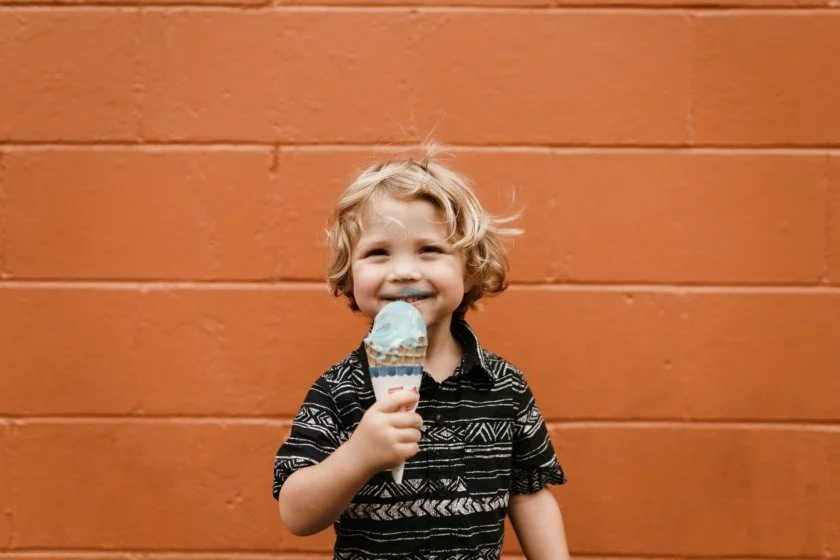 En liten pojke äter glass