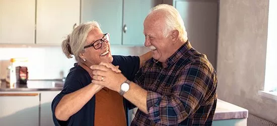 Ett äldre par dansar i ett kök
