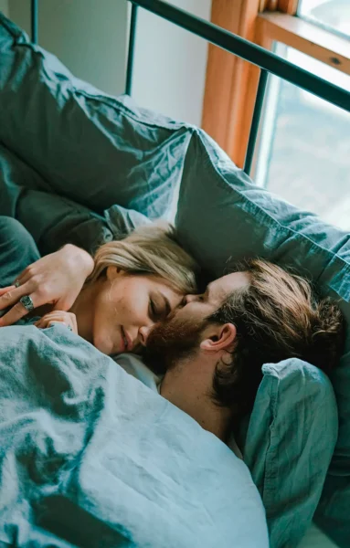 En man och en kvinna kramas i en säng